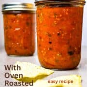 Two mason jars of roasted salsa and a few tortilla chops beside them.