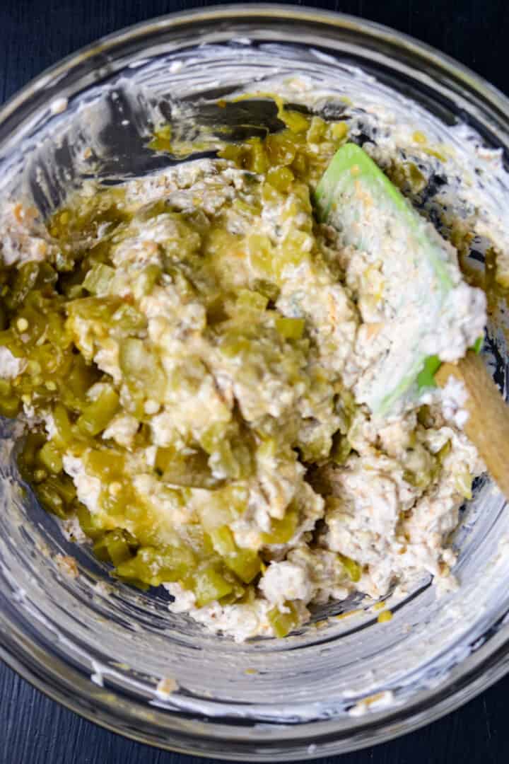A spon in a glass bowl stirring ingredients for boudin dip