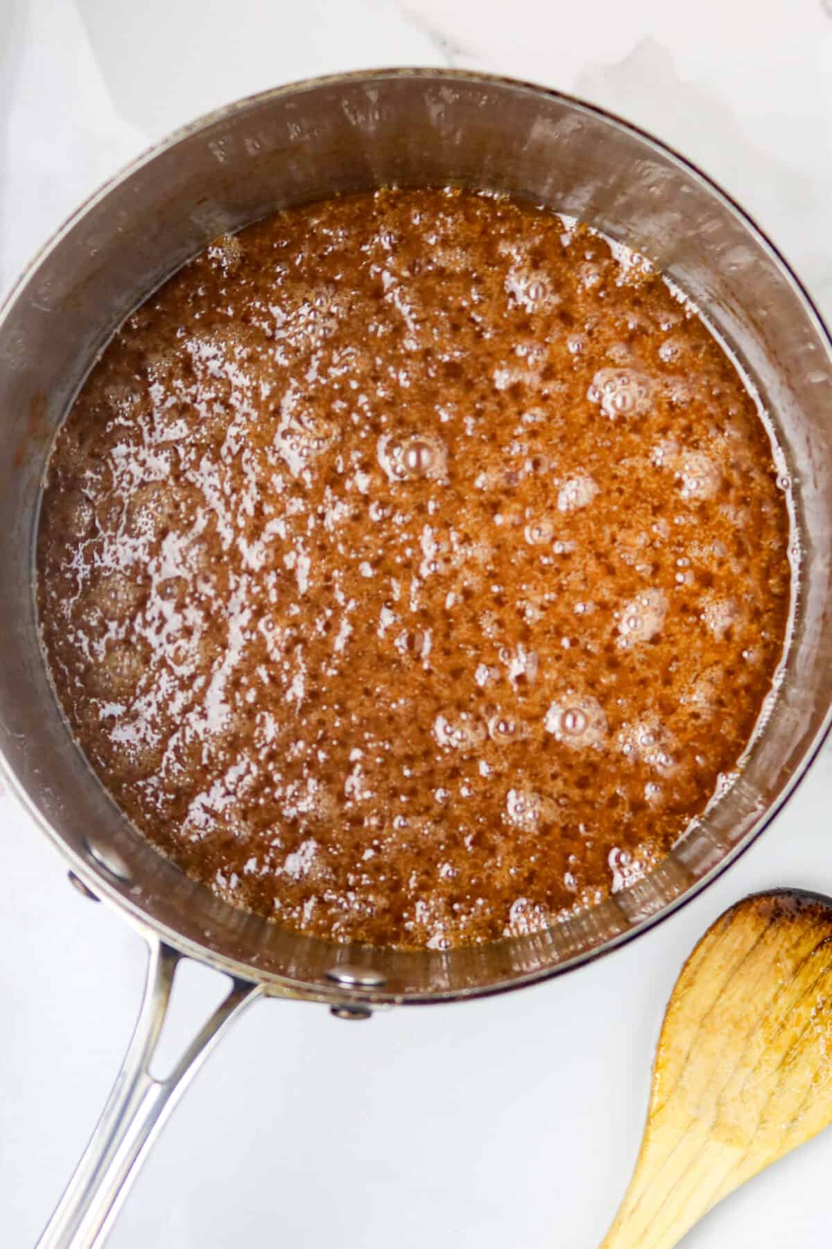 A sauce pan with bubbling candy in it.