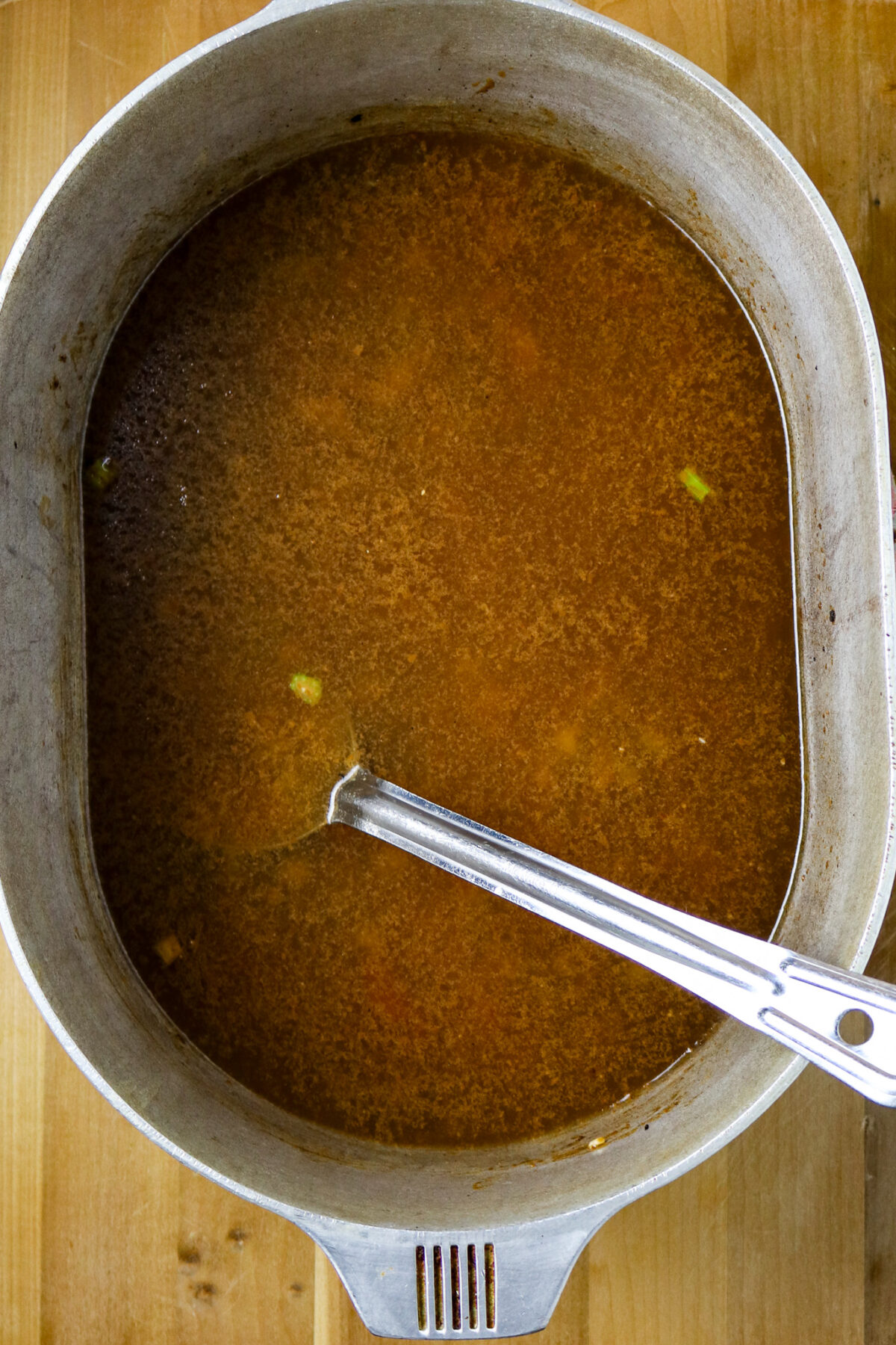 A large pot of gumbo with just roux and broth in it.
