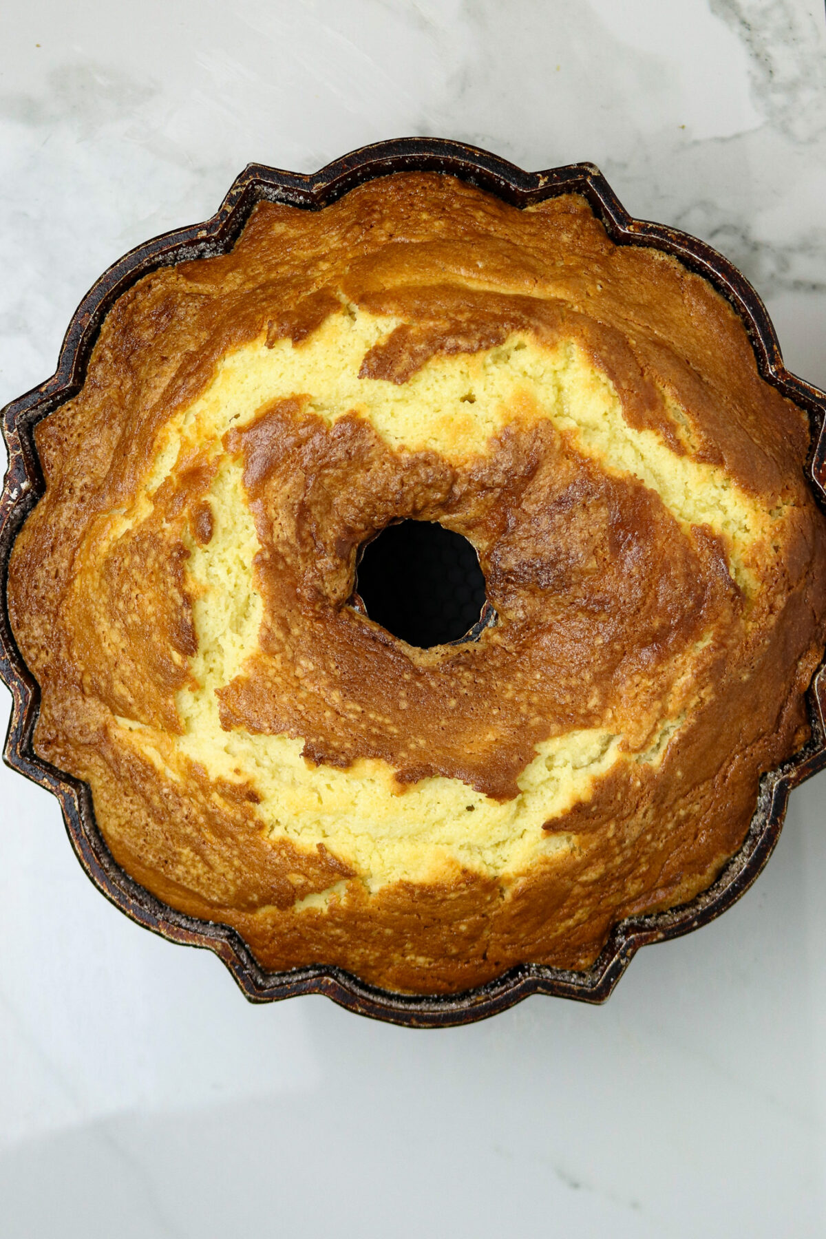 A golden baked cake in a bundt pan.