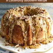 A Louisiana Crunch Cake dripping with a caramel glaze and sprinkled with pecans and coconut.