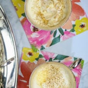 Two silver cups of punch on a colorful napkin.