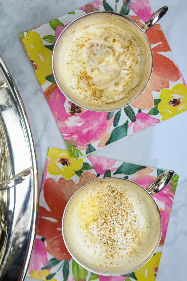 Two silver cups of punch on a colorful napkin.