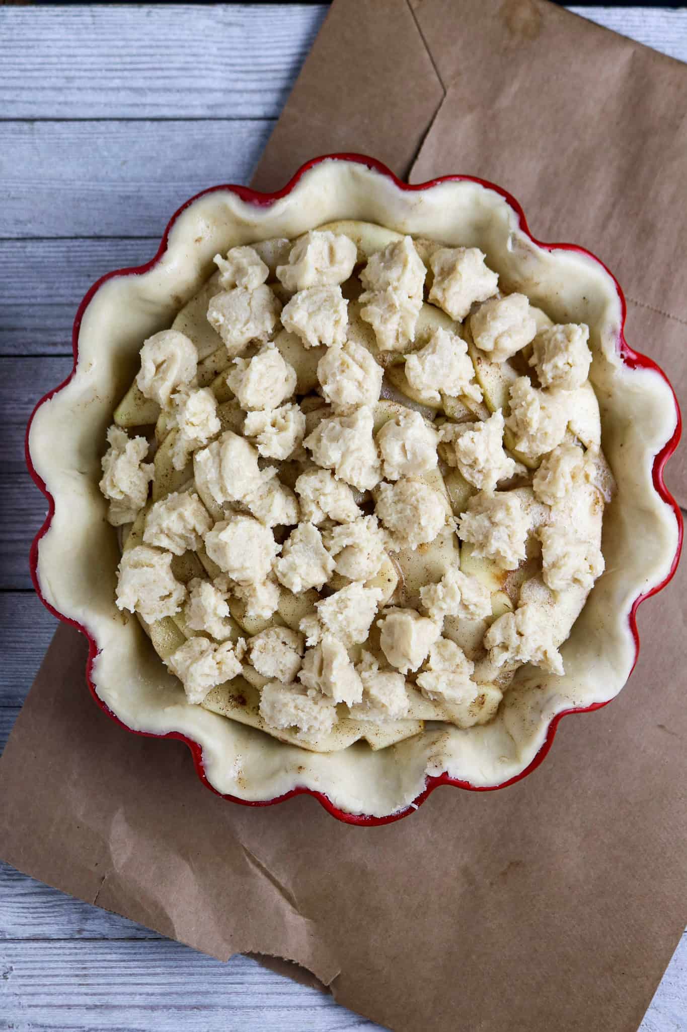 A pre-baked French apple pie topped with dollops of batter.