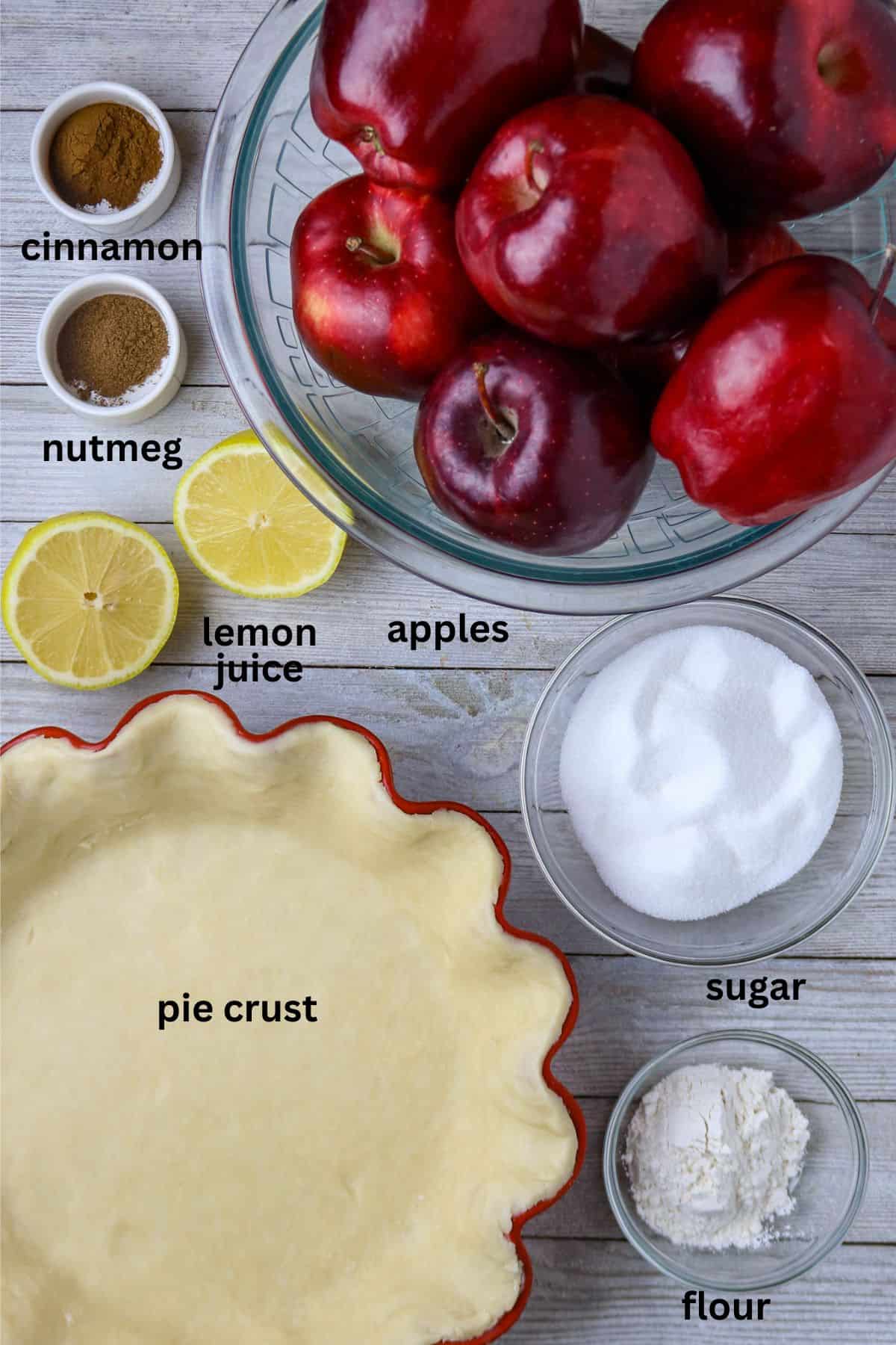 Ingredients of apples, lemon, sugar, spices, and a pie crust for French apple pie filling.