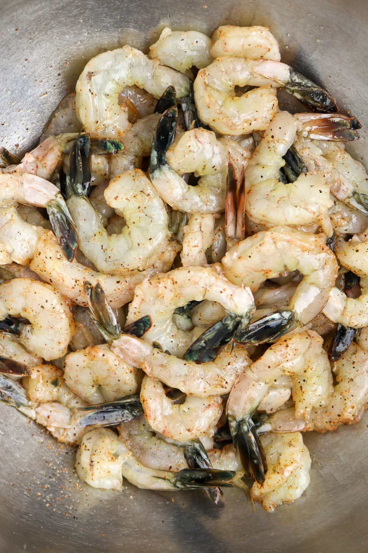 Seasoned raw shrimp with tails forCajun Shrimp and Grits Recipe with Andouille Sausage.