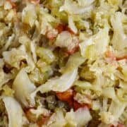 A bowl of cooked cabbage, onions, and tomatoes.