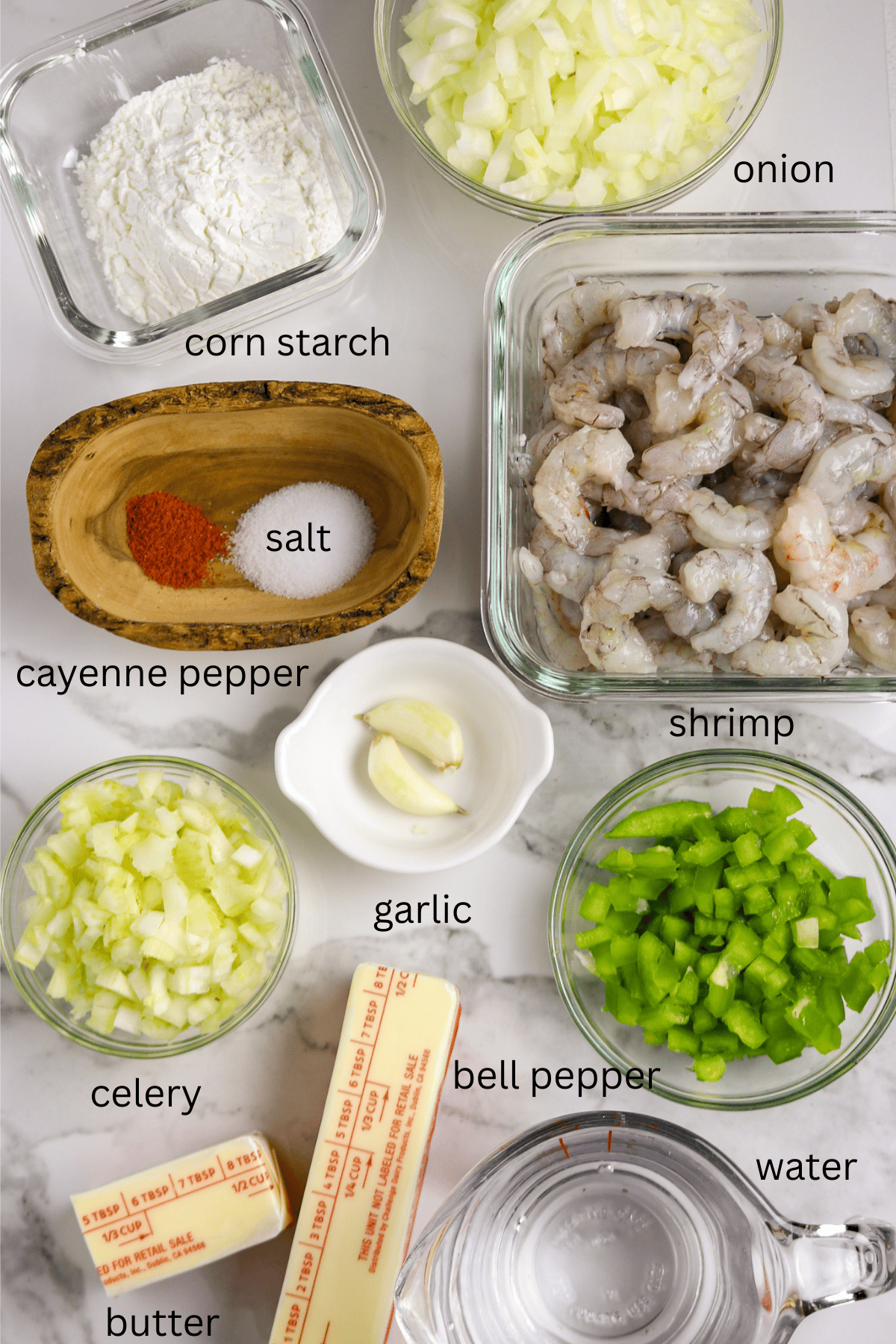 Ingredients of shrimp, butter, vegetables, and seasonings in individual containers.