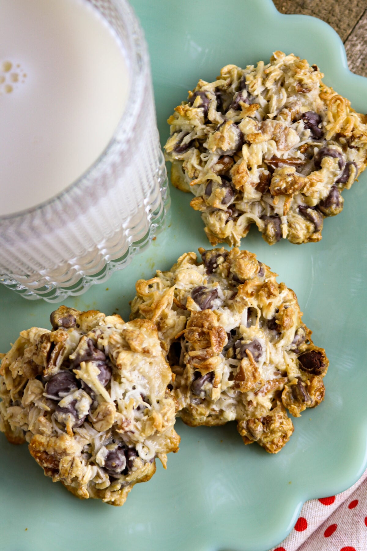 A mint green milk glass plate with a glass of milk and three magic cookies.