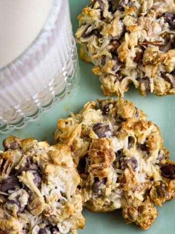 A mint green milk glass plate with a glass of milk and three magic cookies.