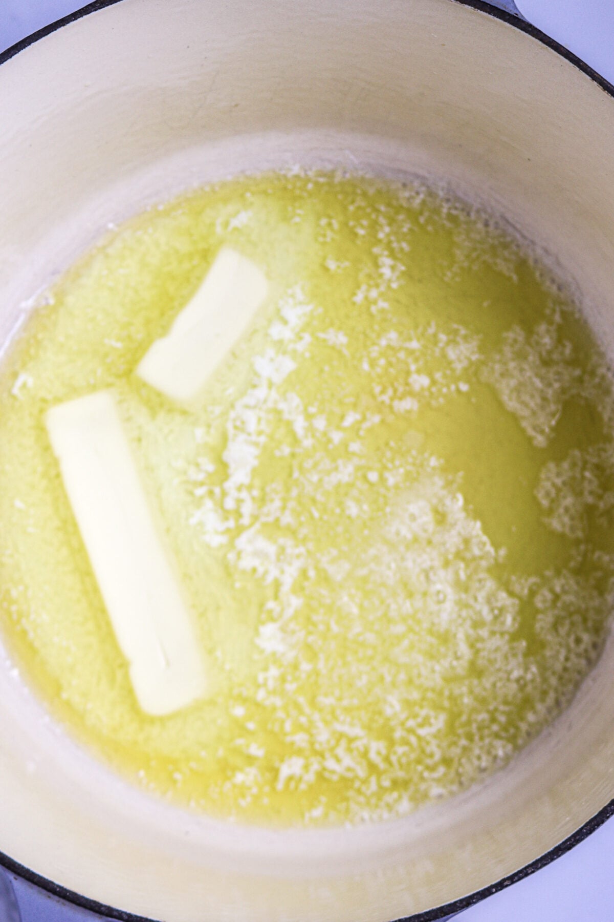 Melted butter in a white Dutch oven.
