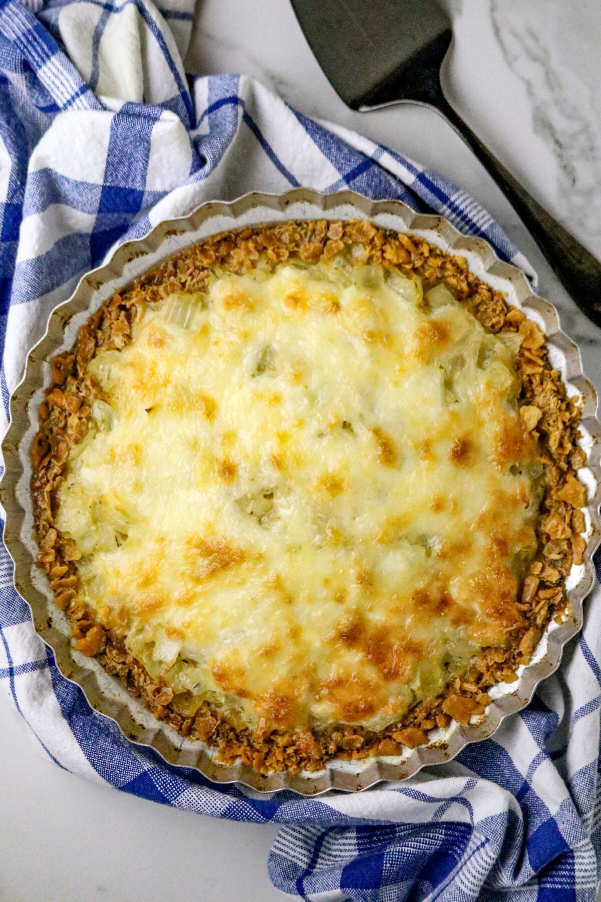 A baked onion pie with browned cheese topping.