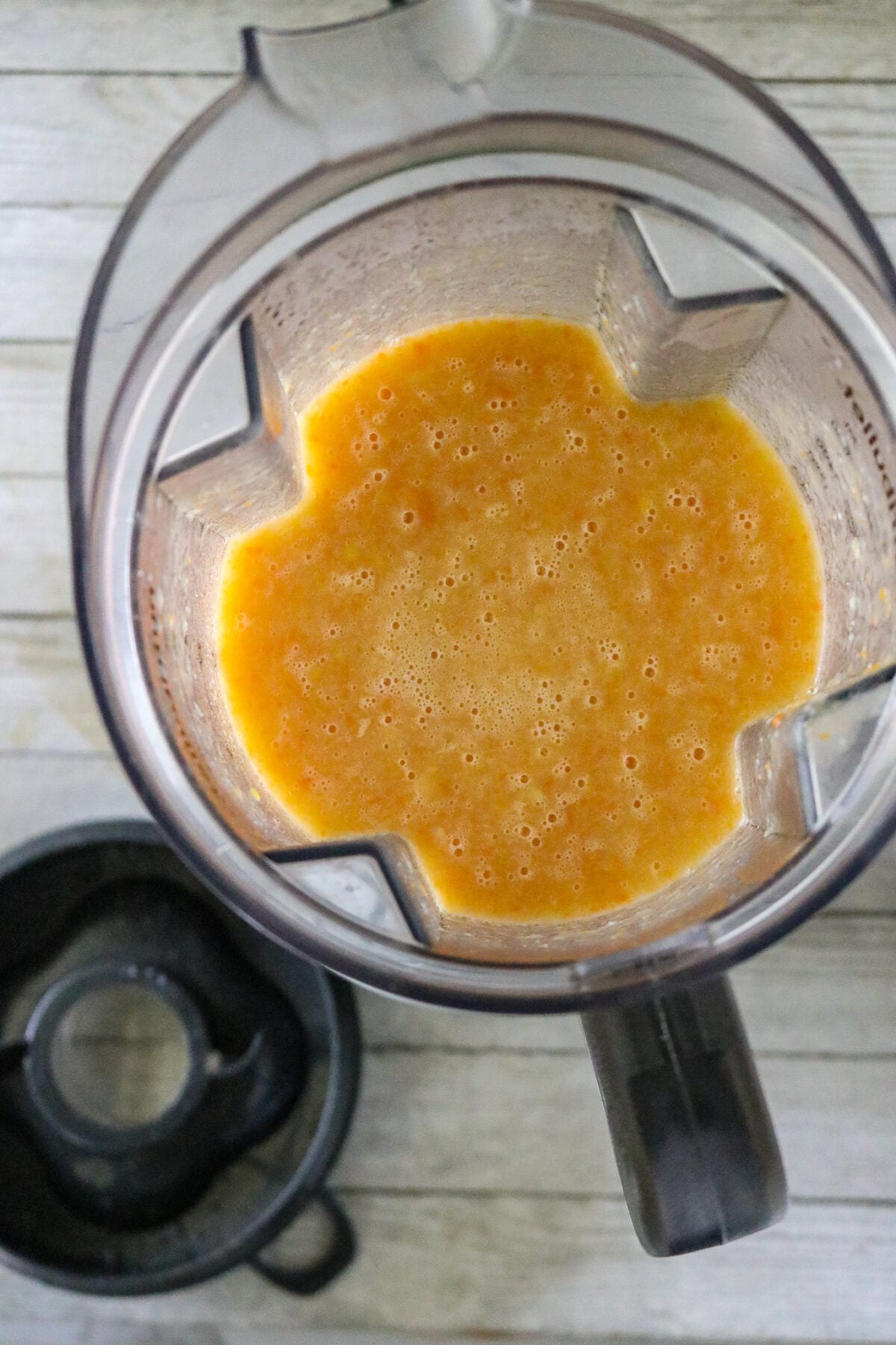 A blender with squash bisques inside it.