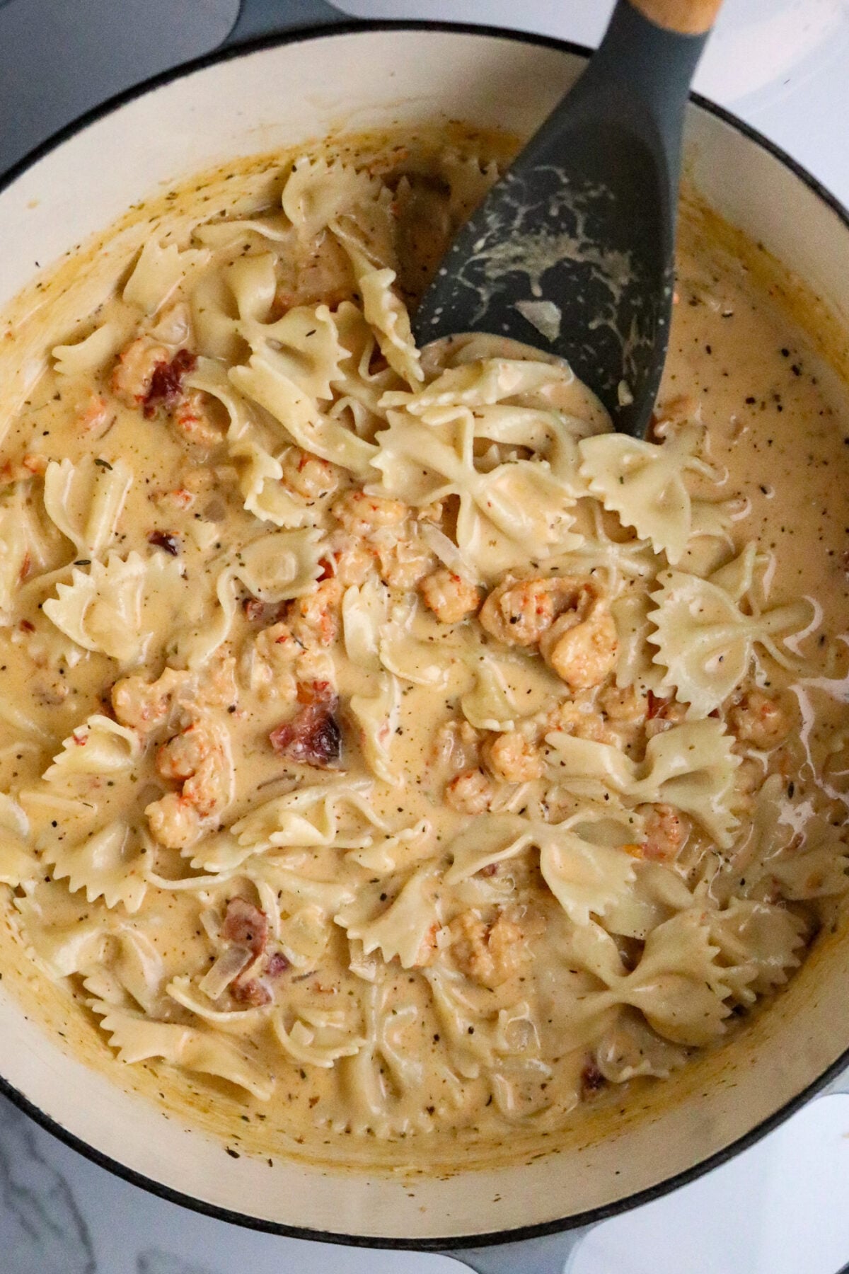 A Dutch oven pot of Marry Me Crawfish which is bowtie pasta in a cream sauce with crawfish.