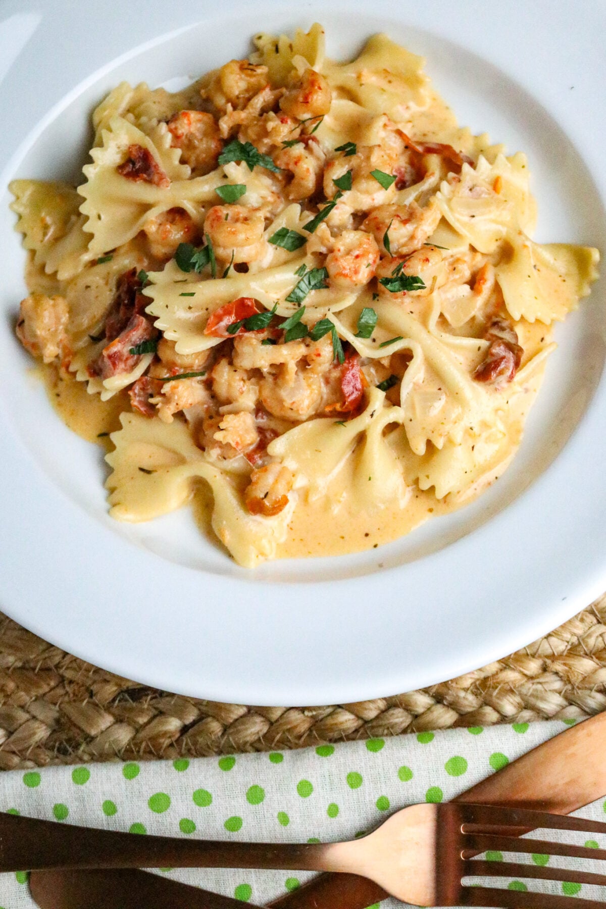 A serving of Marry Me Crawfish which is bowtie pasta in a cream sauce with crawfish in a white pasta bowl.