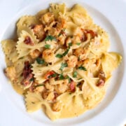 A serving of Marry Me Crawfish which is bowtie pasta in a cream sauce with crawfish in a white pasta bowl.