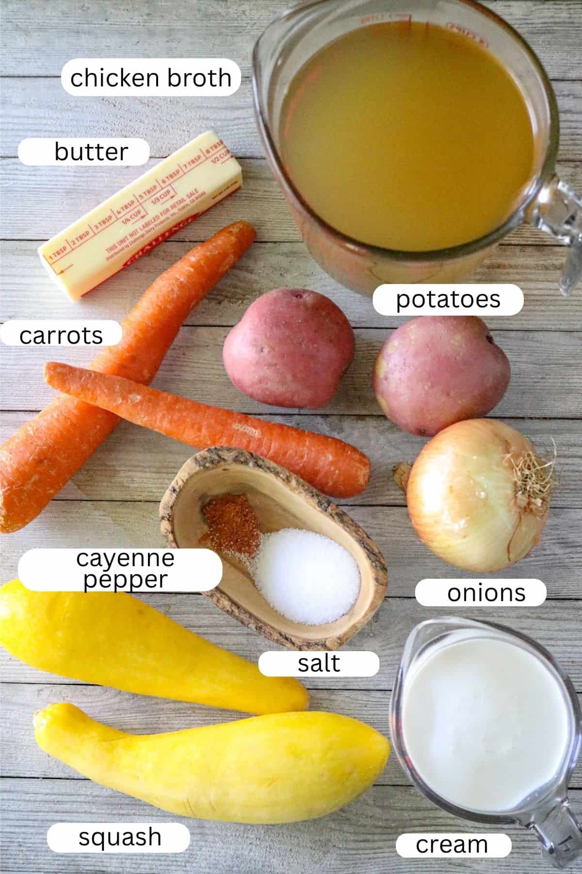 Ingredients for yellow squash bisque with squash, carrots, potatoes, onion, cream, butter, seasonings, and chicken broth.